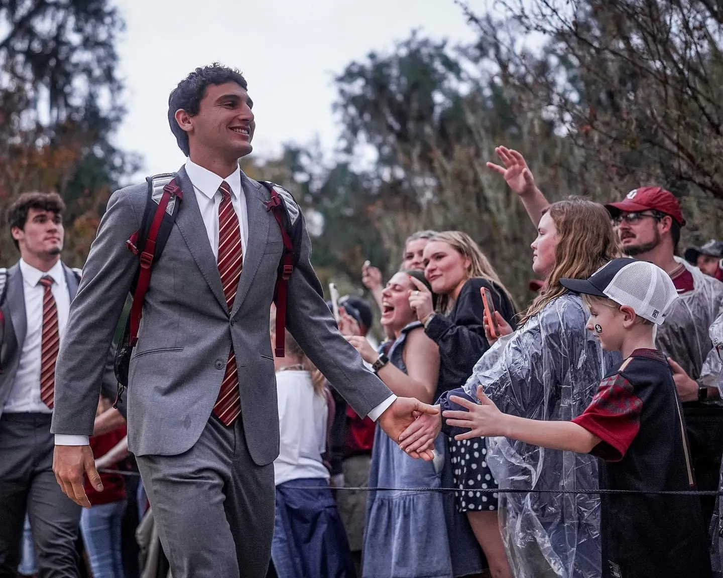 Sportmen wearing grey suits with red ties and white shirts