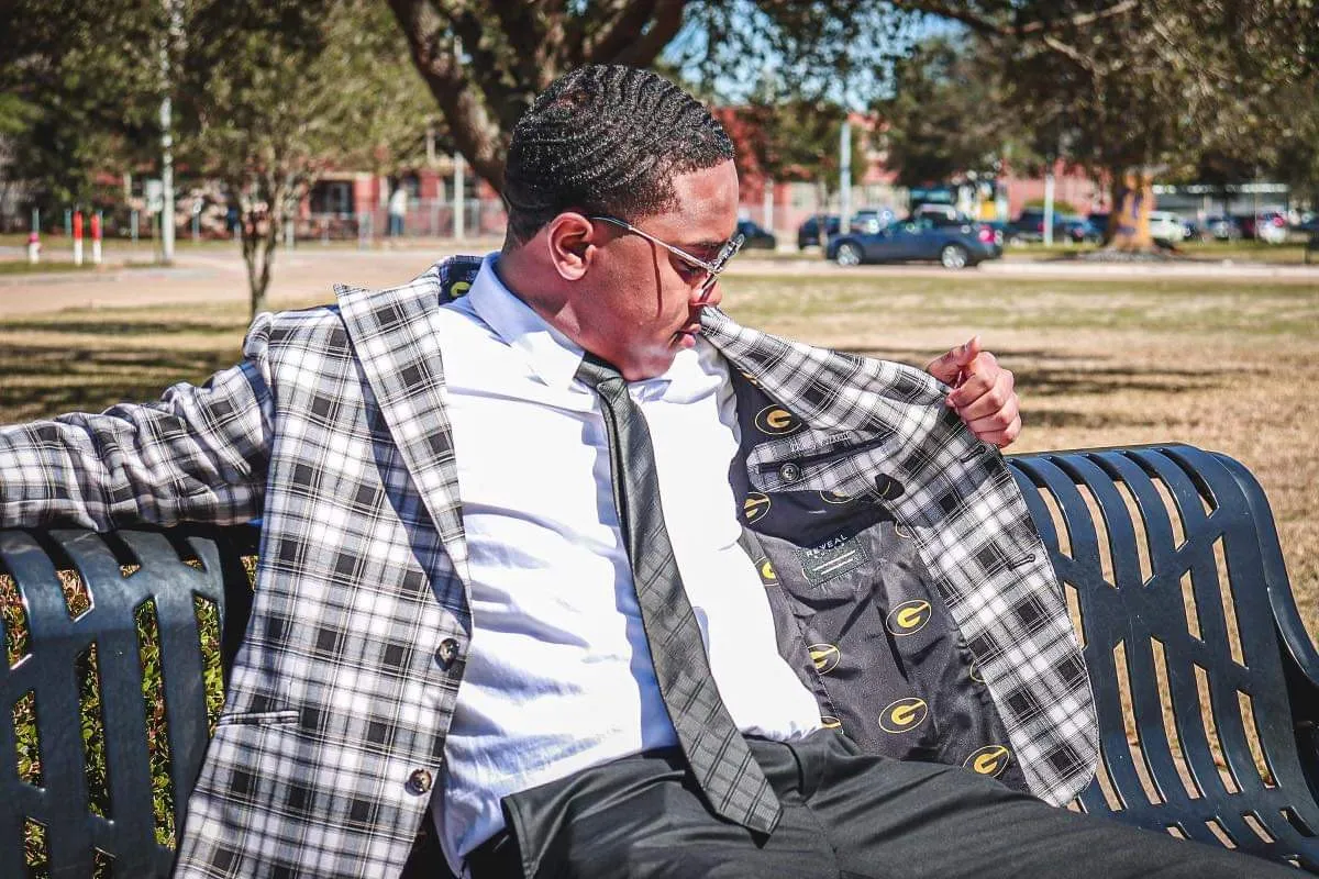 Man sitting in a bench wearing a Reveal suit.