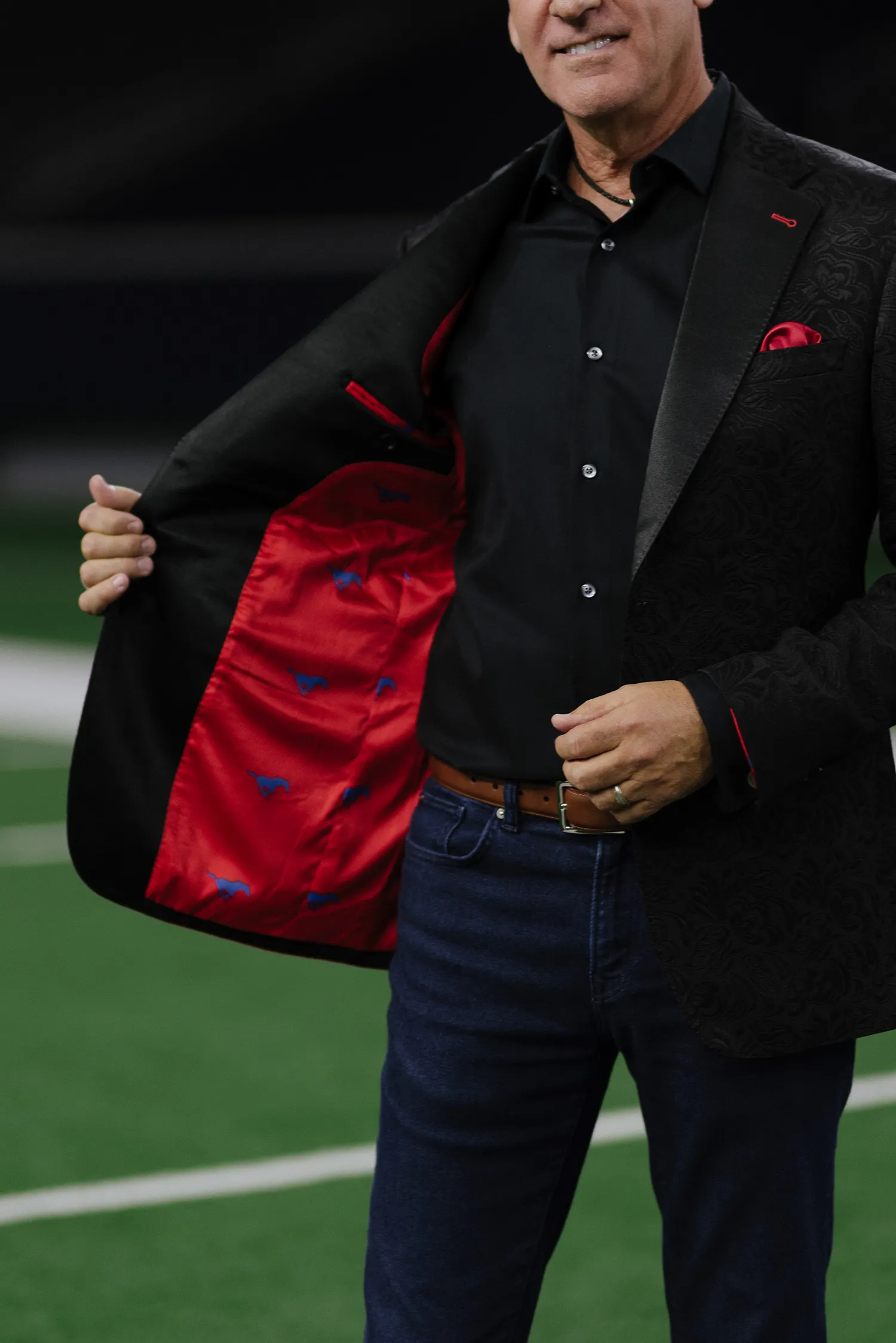 Man in a field wearing a Reveal Suit with red linning.